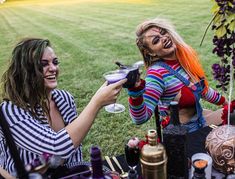 two women dressed up as clowns having drinks