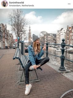 a woman sitting on top of a bench next to a bike