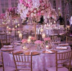 an elegant wedding reception with tall centerpieces and pink flowers on the top table