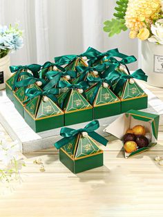 a table topped with boxes filled with different types of candies and fruit next to flowers