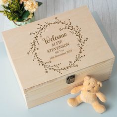 a teddy bear sitting next to a wooden box