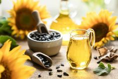 sunflower oil in a glass pitcher next to some seeds and other items on a table