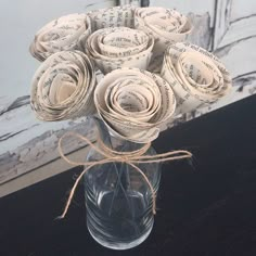 a vase filled with paper roses on top of a table