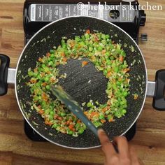 someone is frying vegetables in a wok on the stove