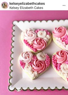 three heart shaped cookies on a plate with pink icing and white frosting in the shape of roses