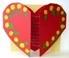 a red heart shaped card with yellow flowers on it