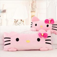 two hello kitty pillows sitting on top of a bed