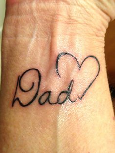 a woman's wrist tattoo with the word dad written in cursive font