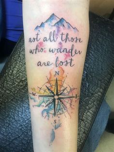 a person with a compass tattoo on their arm that says, not all those who wander are lost