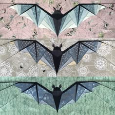 two bat shaped kites sitting next to each other on top of a table cloth