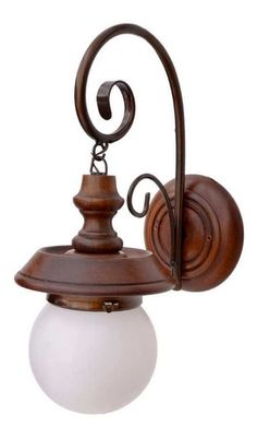 an old fashioned wall light with a white ball hanging from it's back end