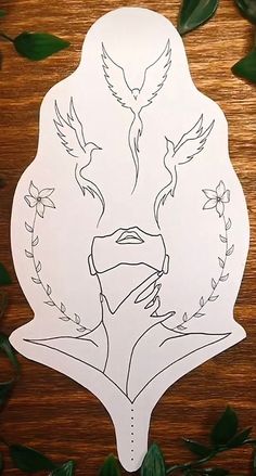 a paper cut out of a woman's face surrounded by leaves