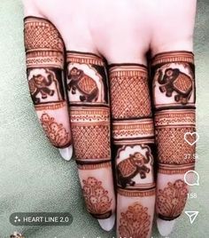 the hand is decorated with henna and elephants