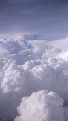 the view from an airplane looking down on some clouds and blue sky with white puffy clouds