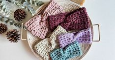 knitted bow ties laid out on a basket next to pine cones