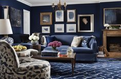 a living room filled with furniture and pictures on the wall above it's fireplace