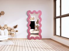 a living room with a white couch and pink mirror