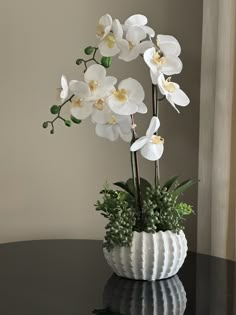 a white vase with some flowers in it