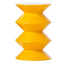 a yellow vase sitting on top of a white table