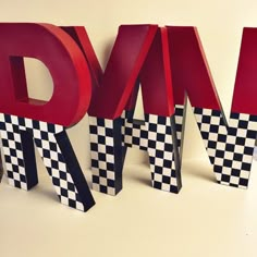 the letters are made out of black and white checkered paper with red lettering on them