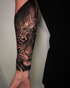 a man's arm with a black and grey tiger tattoo on the left forearm