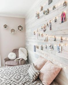 a bedroom with white wood planks and string lights on the wall above the bed