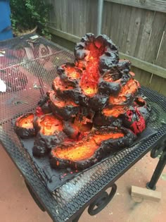 a grill that has some kind of fire in it on top of a metal table