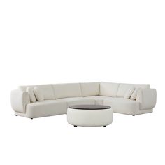 a white couch and ottoman sitting on top of a white flooring covered area with a round coffee table in front of it