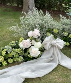 a bouquet of flowers sitting on top of a lush green field next to a tree