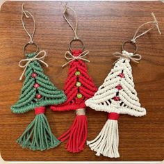 crocheted christmas tree ornaments are hanging on a wooden table with twine cord