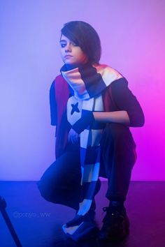 a woman sitting on top of a wooden floor in front of a purple and blue background