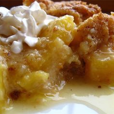 a close up of a plate of food with bananas and whipped cream on the top