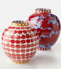 two red and blue vases sitting next to each other on a white table top