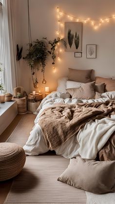 an unmade bed in a bedroom with string lights on the wall and potted plants