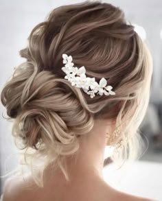 a woman with blonde hair wearing a wedding hairstyle