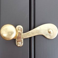 a close up of a door handle on a black and gold door with two knobs