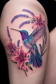 a woman's thigh with a hummingbird and flowers on it