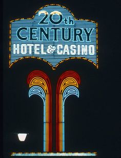 the 20th century hotel and casino sign is lit up in blue, red, yellow and orange