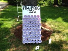 a ping pong toss game is set up in the grass next to a tree