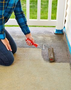 a woman kneeling down on the ground with a tool