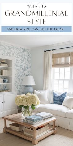 a living room with white furniture and blue flowers on the coffee table in front of it