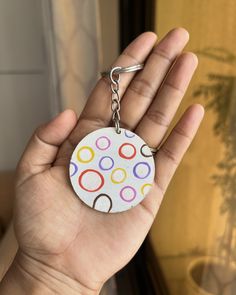 a hand holding a keychain with circles on it