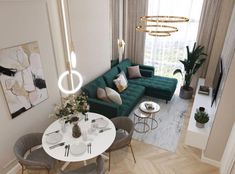 an aerial view of a living room and dining area with green couches, white table, grey chairs, gold chandelier