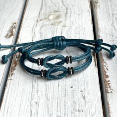 two blue leather bracelets sitting on top of a wooden table