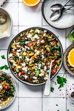 a bowl filled with salad next to other dishes and utensils