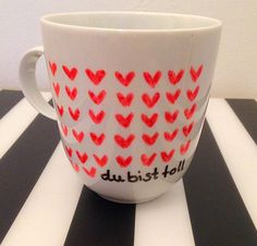 a coffee cup with red hearts painted on it