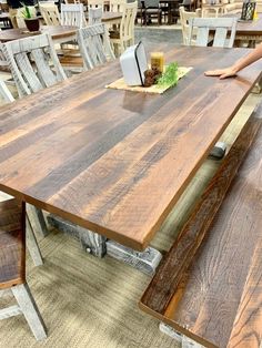 a wooden table with two benches in front of it and people sitting at the tables