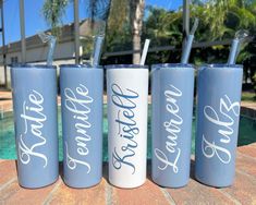 three personalized tumblers with straws in them sitting next to a swimming pool