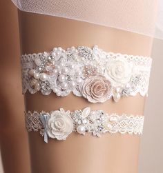 three garters with flowers and pearls on them