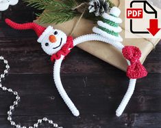 a christmas ornament with a snowman hat and scarf hanging from it's side